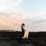 Casal de recem-casados na costa ao por do sol — destinos romanticos para lua de mel