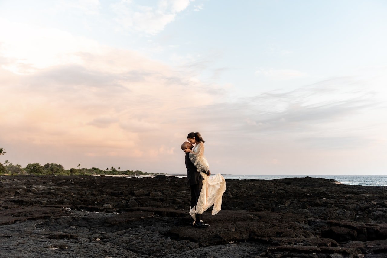 Casal de recem-casados na costa ao por do sol — destinos romanticos para lua de mel