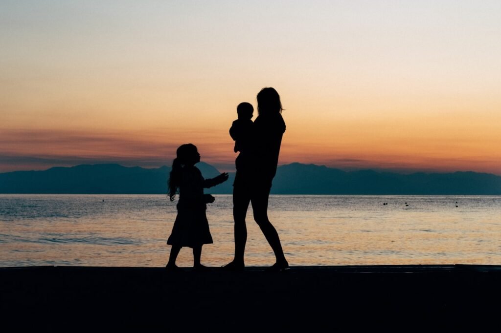 Mae com filhos na praia durante as ferias — viagens em familia com criancas, dicas e planejamento