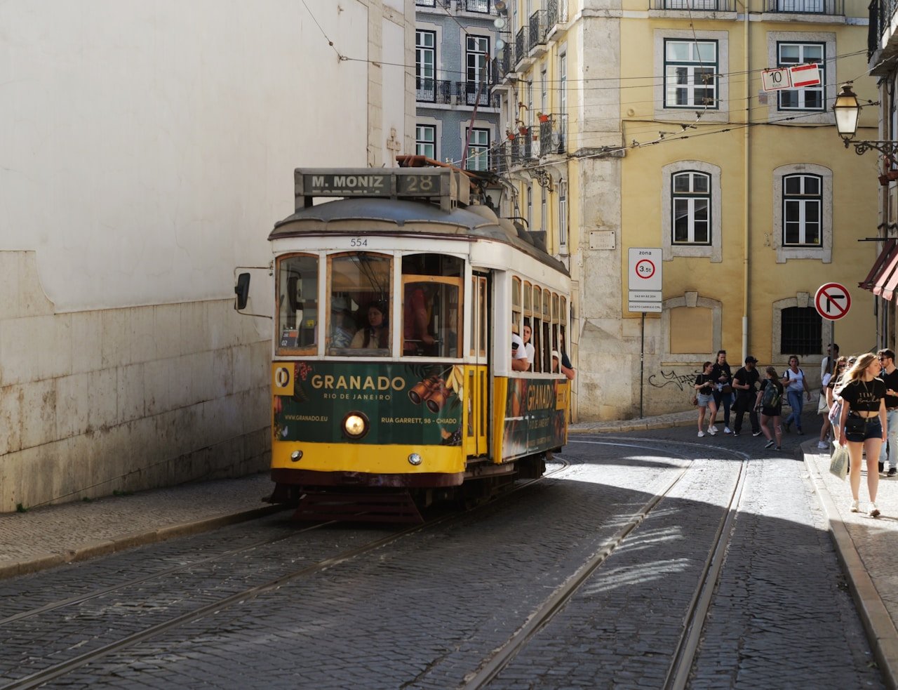 Bonde amarelo histórico percorrendo as ruas de Lisboa — uma das cidades mais charmosas e baratas da Europa