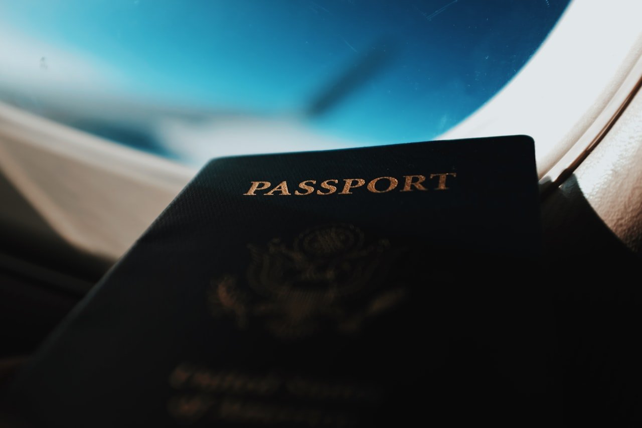 Passaporte com silhueta de aviao ao fundo — documentos essenciais para a primeira viagem internacional