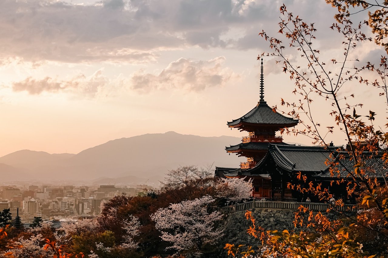 Templo japonês cercado de cerejeiras em flor ao entardecer — Kyoto é um dos destinos mais desejados do Japão