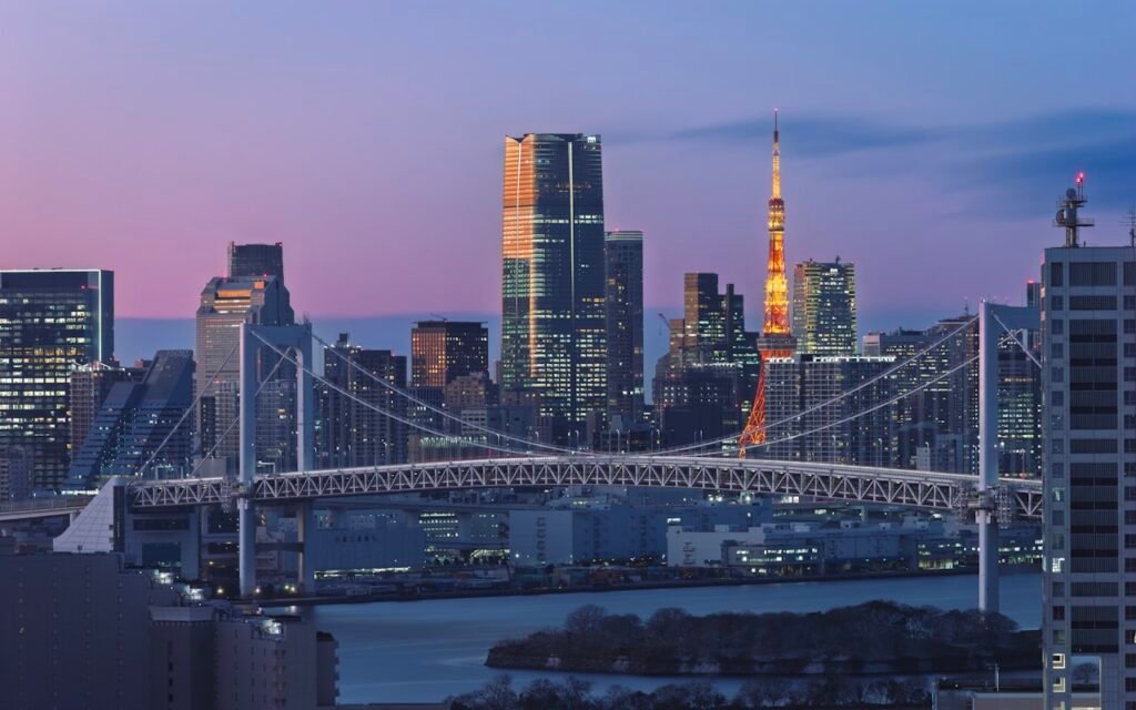 Skyline de Toquio com a Rainbow Bridge iluminada ao entardecer — viagem economica ou de luxo no Japao