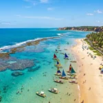 Praia paradisiaca do Nordeste do Brasil com piscinas naturais, jangadas, coqueiros e falesias