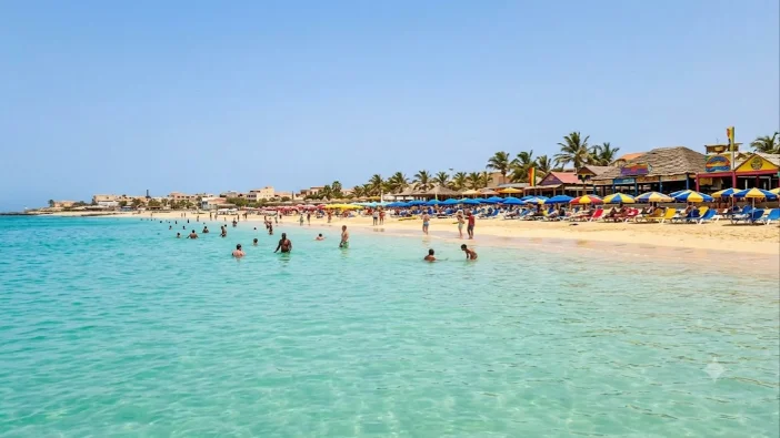 Praia de Santa Maria na ilha do Sal com guarda-sois coloridos e agua cristalina