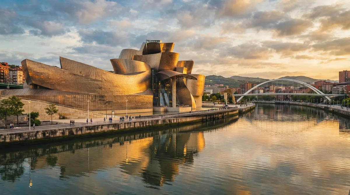 O que fazer em Bilbao: vista do Museu Guggenheim Bilbao ao entardecer, refletido na Ría do Nervión