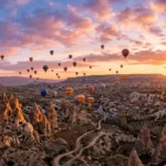 Balões de ar quente sobrevoando a Capadócia, Turquia, ao nascer do sol